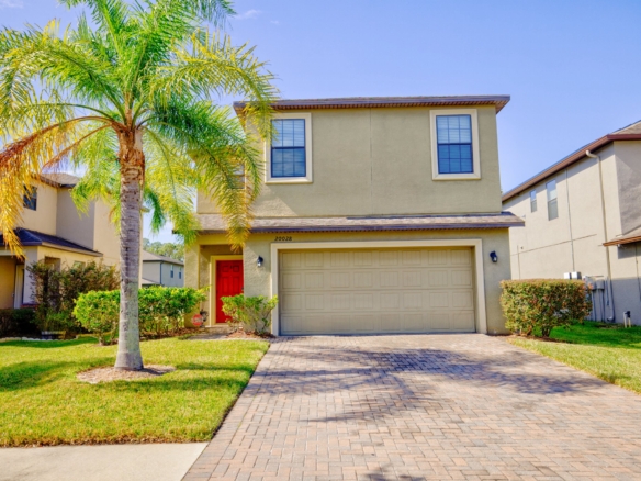 Front exterior of 20028 Satin Leaf Ave, Tampa FL — red door and house number 20028 visible